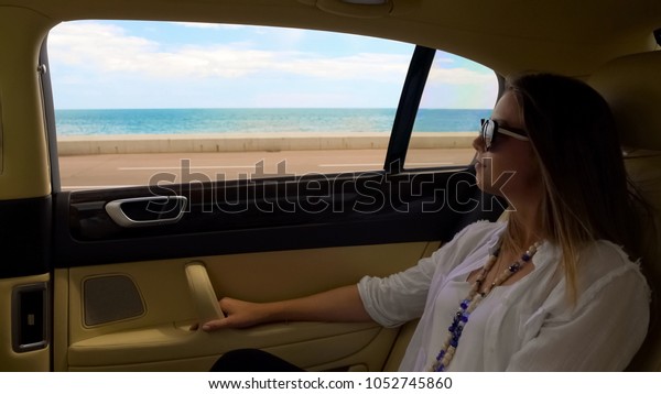 Rich lady having trip in luxury car at seafront\
road, luxury vacation in\
resort