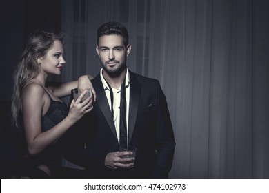 Rich Macho Young Man Drink Whiskey With Blonde Lover At Night