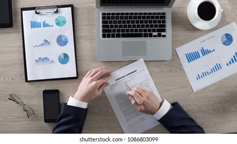 Rich male reading and learning purchase agreement in office, business, top view - Shutterstock ID 1086803099