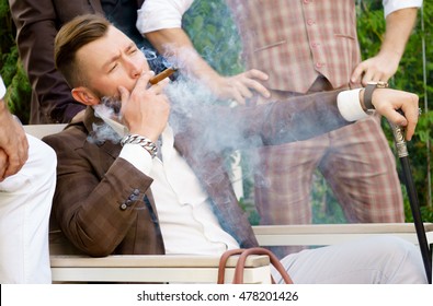 Rich Man In Elegant Clothes With Cane And Smoking Cigar