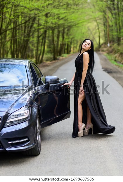Rich people lifestyle. Start journey. Buy expensive\
auto. Symbol of richness. Luxury car. Auto and pretty sexy woman at\
road. 