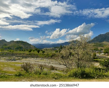 The rich vegetation, open fields, and variety of trees create a sense of calm and tranquility, showcasing the charm of rural life. - Powered by Shutterstock