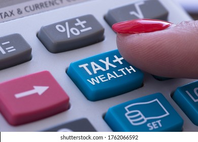 Rich Or Wealth Taxation Concept With Woman Finger Pressing Tax Button Of Pocket Calculator