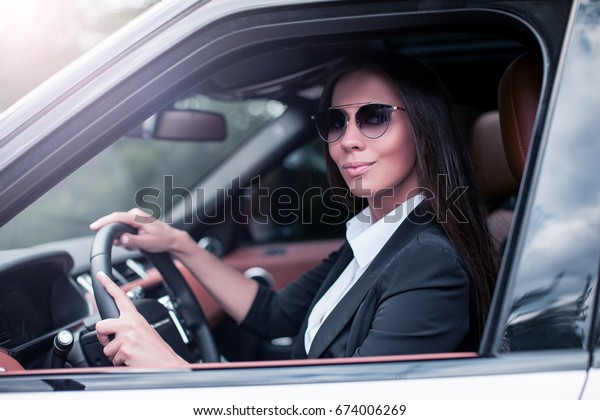 Rich  Woman\
in a suit Driving Luxury Car.     \
 \
