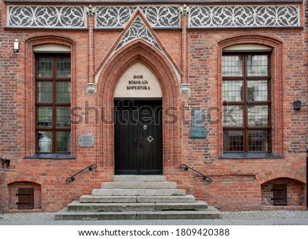 Richly decorated front facade and entrance to a historic, medieval, gothic tenement house - The Nicolaus Copernicus House in Toruń, Poland. Selected focus.