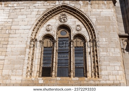 Richly decorated Gothic window with carved arches of the Toledo Cathedral (The Primatial Cathedral of Saint Mary of Toledo), Spain.