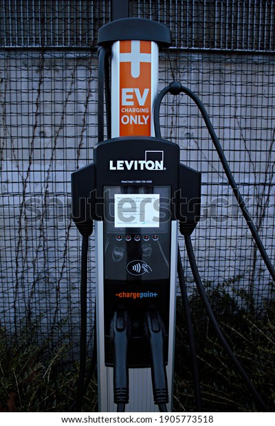 Richmond, BC, Canada- 01 29 2021: A Leviton\
electrical vehicle charging station with 2 charging lines and the\
charging prices on the screen.\
