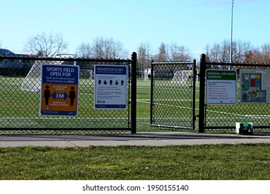 Richmond, BC, Canada- 04 05 2021: An Open Gate To A Sports Field With A Sign Saying The Field Is Open For Use For Youth Sports With A Permit And Individual Use For Those 19 Or Older. 