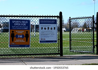 Richmond, BC, Canada- 04 05 2021: An Open Gate To A Sports Field With A Sign Saying The Field Is Open For Use For Youth Sports With A Permit And Individual Use For Those 19 Or Older. 