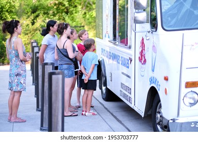 Richmond Hill, Ontario, Canada - June 29, 2019 :  Family With Kids Line Up In Front Of Ice Cream Food Truck To Order Delicious Sweet Ice Cream Cones, Shakes. Enjoy The Summer Fun At Lake Wilcox Park.