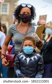 Richmond, North Yorkshire, UK - June 14, 2020: Strong Female Leader Wears Black Lives Matter PPE Face Mask And Hugs Superhero Son At BLM Protest In Richmond, North Yorkshire