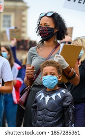 Richmond, North Yorkshire, UK - June 14, 2020: Strong Female Leader Wears Black Lives Matter PPE Face Mask Along With Superhero Son At BLM Protest In Richmond, North Yorkshire