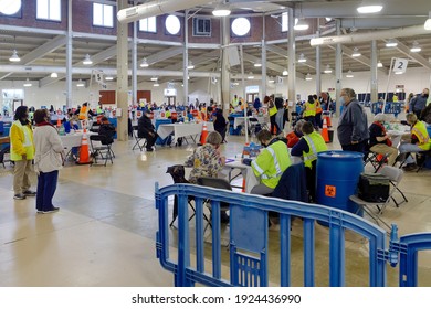 Richmond, Virginia United States February 22,2021. Indoor covid vaccination center. Attendants wearing day-glo vests directing seniors and frontline workers to inoculation stations.