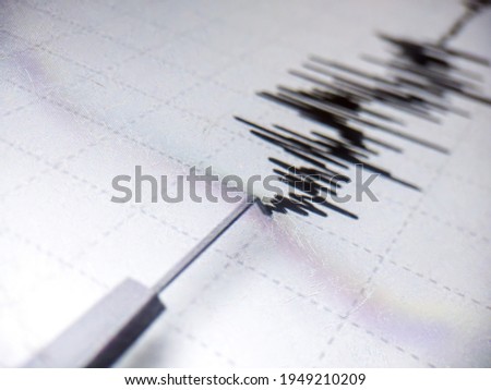 Richter scale Low and High Earthquake Waves with Vibration on white paper background, audio wave diagram concept, photo of cellphone screen, Aceh Indonesia
