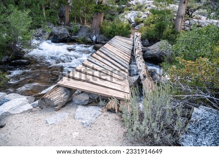 Rickety bridge, broken up with the main support log separated and the boards all leaning to one side, Bishop Creek, Lake Sabrina, California