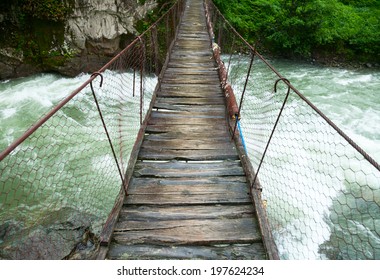 Rickety foot bridge over white water