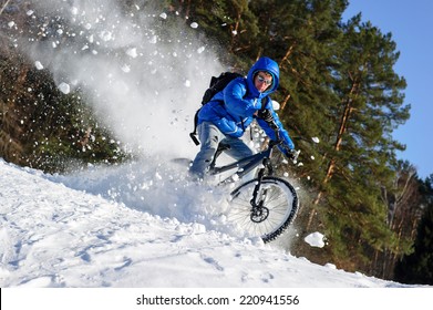 Rider Cycling On A Mountain Bicycle In The Snow In The Winter Forest