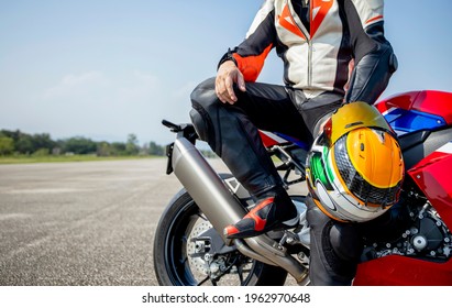 rider motorbike holding his motorcycle helmet sitting on a big bike in the road riding with soft-focus and over light in the background