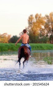  rider with a naked torso skips astride a horse down the river