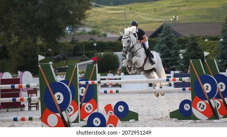 Rider on a gray horse. Equestrian sport. Horse jumping. Show jumping. Horse riding theme photo.