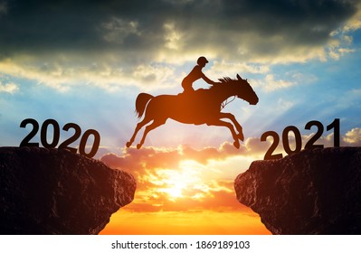 The rider on the horse jump from 2020 to 2021 at sunset. Happy New Year concept.