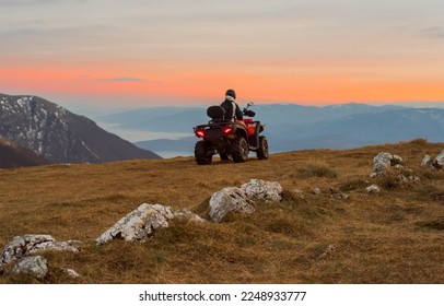 A rider riding quad bike atv off road on the mountain at sunset adventure travel. - Powered by Shutterstock