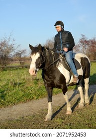 The Rider Sits On A Piebald Horse