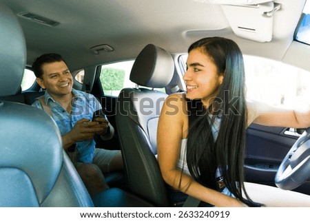 Rideshare driver and client engaging with a mobile phone app while inside a car, navigating through the urban landscape for convenient travel