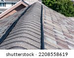 Ridge cap vent installed on a shingle roof for passive attic ventilation on a residential house. 