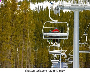 Riding The Chairlift In Lake Louise Ski Resort Surrounding By Forest In Alberta, Canada.