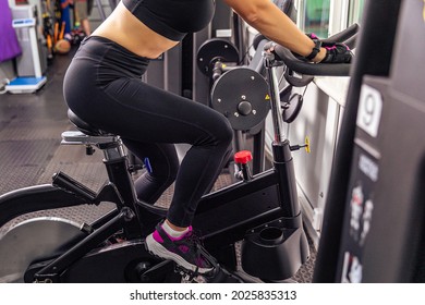 Riding an exercise bike. Gym. Woman on an exercise bike