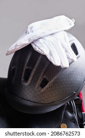 Riding Helmet And Gloves  Puted At Saddle . Equestrian Riding Concept. Close Up