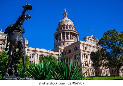 Riding a Horse to the Left of Texas State Capital building on a nice clear blue sky day with Sunlight hitting the Front of the capitol fresh green plants in the foreground with Government