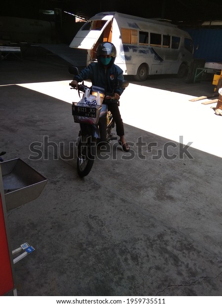 riding a\
motorcycle, location: Mojosongo, Jebres sub-district, Surakarta\
city, Central Java, Indonesia, April 21,\
2021