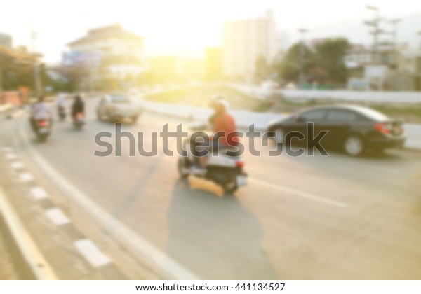 Riding a motorcycle on a curved road in the city.\
image blur style.
