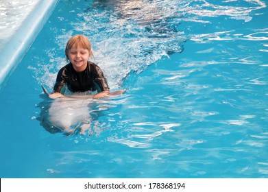 Riding on a dolphin at the dolphin therapy session