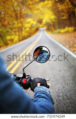 Riding on Motorcycle through Autumn Leaves Street Motorcycle Ride on Scenic Tree lined Road with Colorful Fall Foliage of Golden Yellow Orange Colors