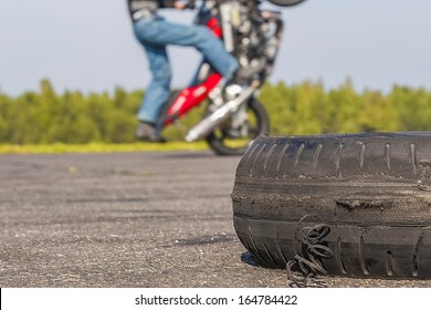 Riding On One Wheel Motorcycle And Worn Tire In The Foreground.