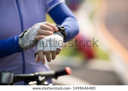 Riding on park bike path, set the smartwatch while riding bike on sunny day