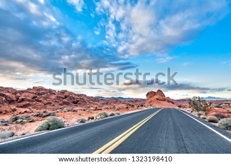 Riding on the scenic road out of the Valley of Fire before sunset towards the sky on the horizon and strange peculiar rock formations near Las Vegas, Nevada, United States.