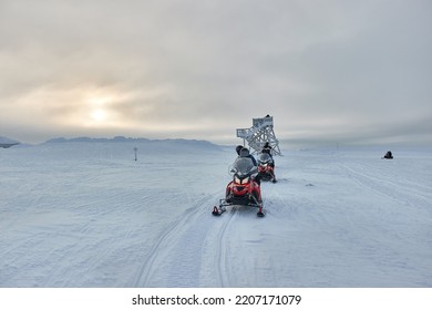 Riding on a snowmobiles in Finland, group adventure above the Arctic Cirlce, unrecognizable riders in helmets