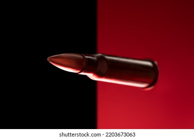 Rifle Bullet Long Cartridge On Black Red Background. Army Or Hunting Weapon Shot Object, Violence And Danger Symbol.