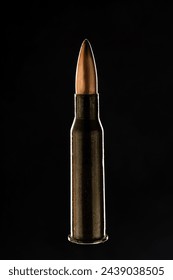 Rifle bullet long cartridge on black background. Army or hunting weapon shot object, violence and danger symbol.