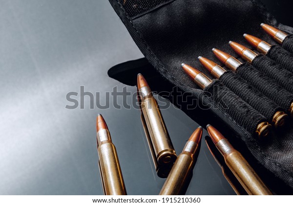 Rifle\
bullets or cartridges on black shiny\
background