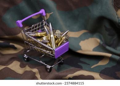 Rifle cartridges in small shopping cart. Big caliber ammo cartridges with a small shopping basket close up