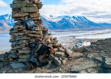 Rifle And Snow Shoes Overlooking Longyearbyen City, Svalbard, Norway