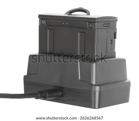 Riflescope's power source that has been taken outof the night vision optic and in the cradle for recharding isolated on a white background.