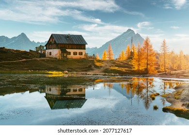 Rifugio Croda on Federa Lake in sunrise time. Autumn mountains landscape with Lago di Federa and bright orange larches in the Dolomite Apls, Cortina D'Ampezzo, South Tyrol, Dolomites, Italy