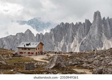 Rifugio Lavaredo with beautiful mountain peaks of Cadini group in Sexten Dolomites. Mountain hut with tourists on the loop trail around Tre Cime di Lavaredo, Dolomites, South Tyrol, Italy.