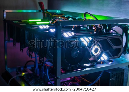 Rig of six video cards. Cryptocurrency concept. gpu render farm. Mining background. Neon LED backlight.